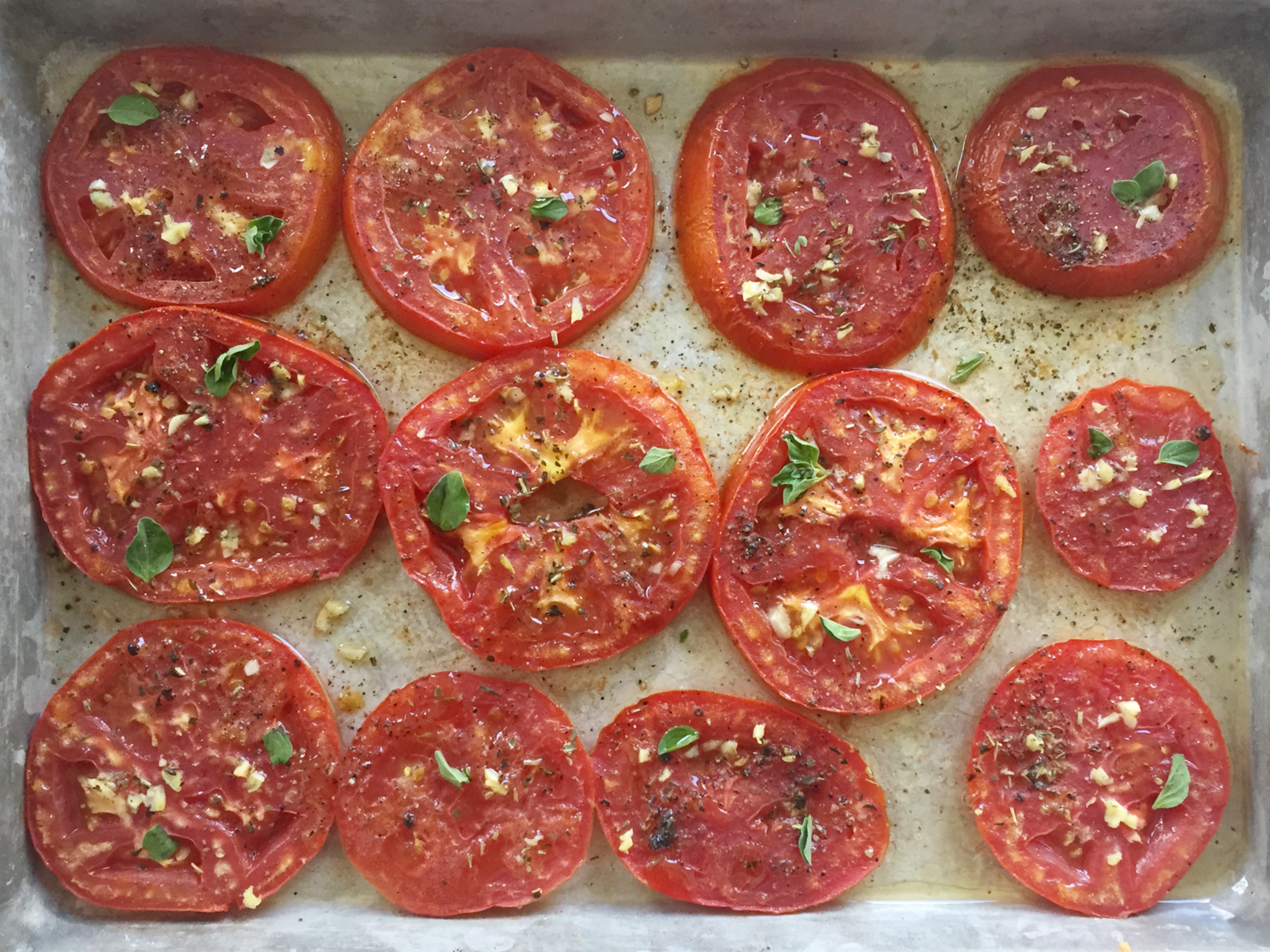 baked tomato slices Baked tomato slices on a sheet tray.