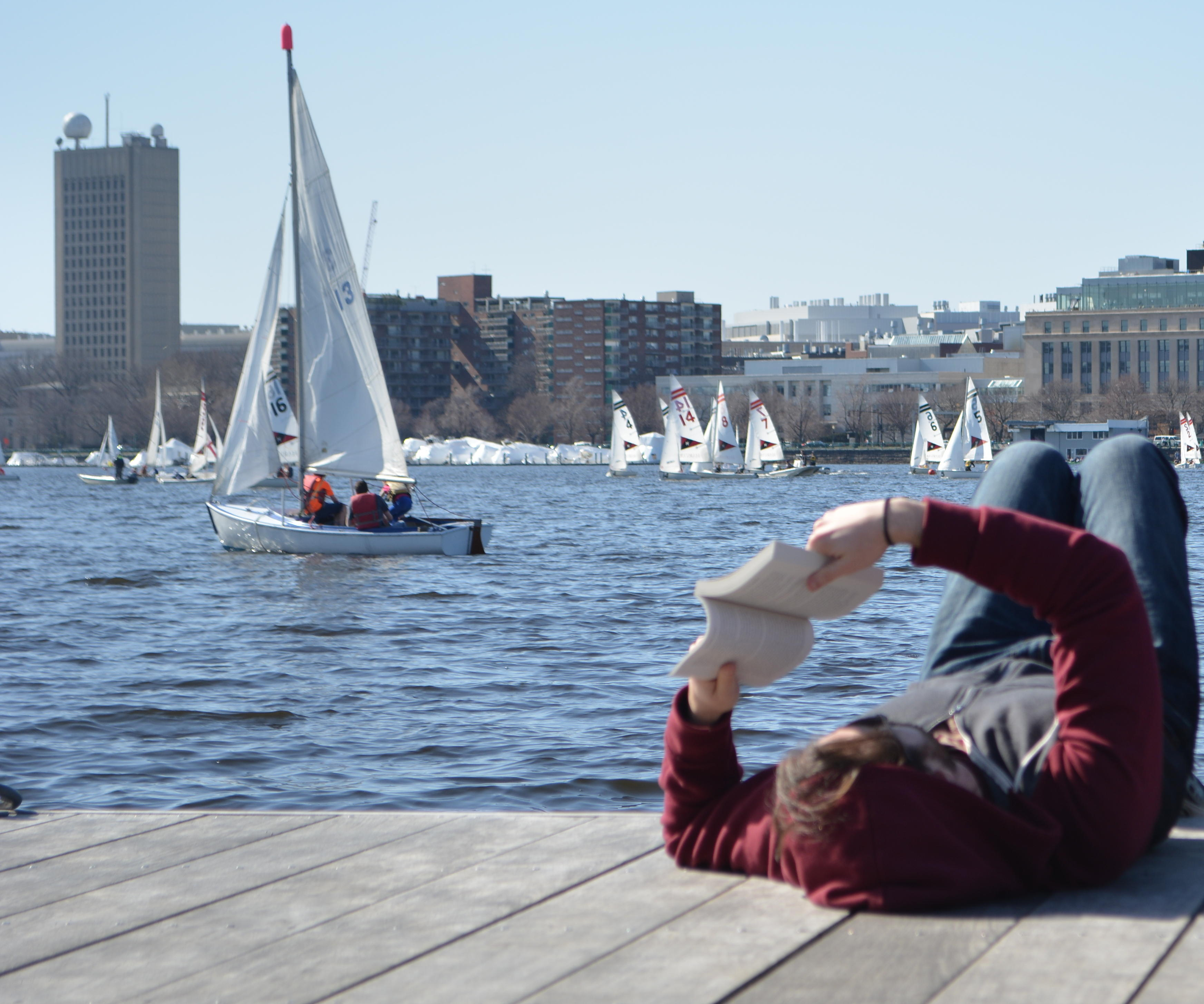 Person lounges on a dock on the Charles River Esplanade in Boston, Massachusetts