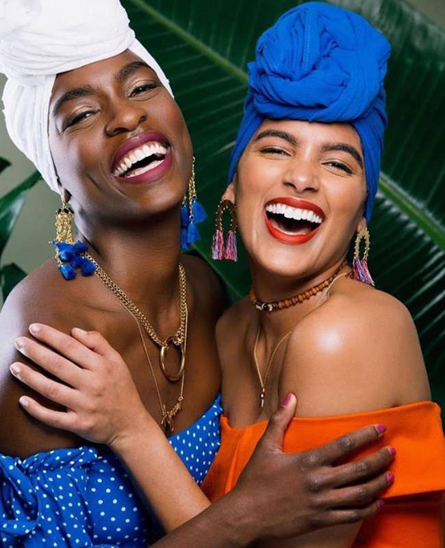women laughing and hugging Women laughing and hugging wearing headwraps