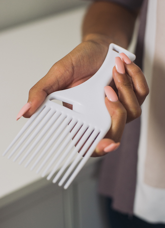 Woman holding hair pick comb