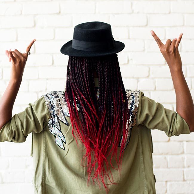 gerilyn hayes wears sequined military-style jacket, with black hat on top of ombre red box braids