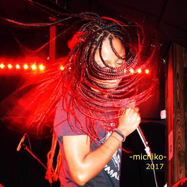 Gerilyn on stage whipping red and black braids around with her band Sugarpill.