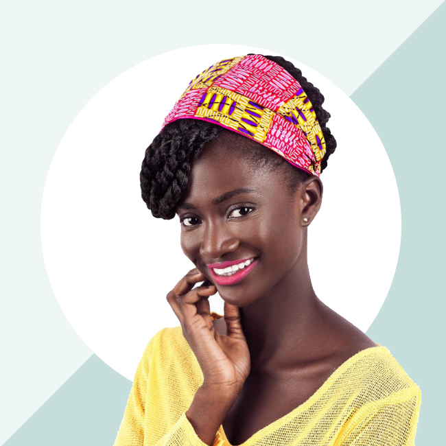 A smiling deep skinned model shows off a bright smile and the Loza Tam Pink (multicolored print) headband